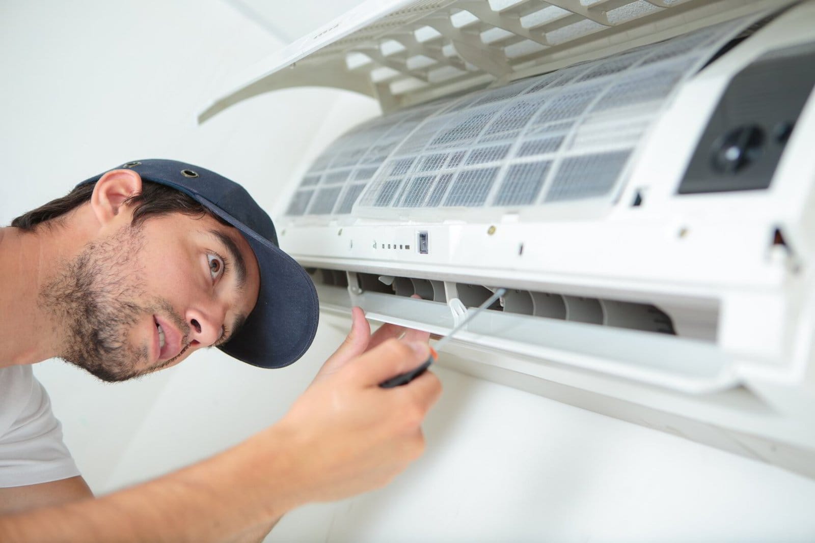 Technician repairing an air conditioning unit.
