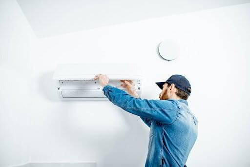 Technician servicing an air conditioning unit.