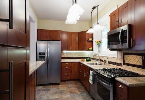 Modern kitchen interior with stainless steel appliances and wooden cabinets.