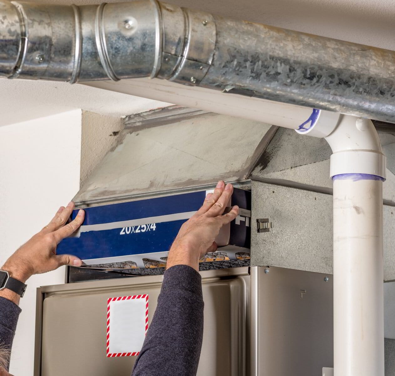Person replacing an air filter in an hvac system.