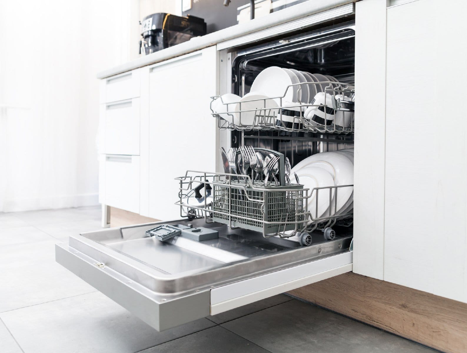 Open dishwasher filled with clean dishes in a modern kitchen.