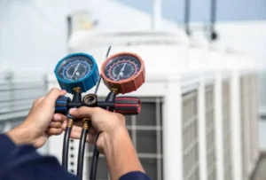 HVAC technician using pressure gauges for air conditioning repair services, with AC units in the background.