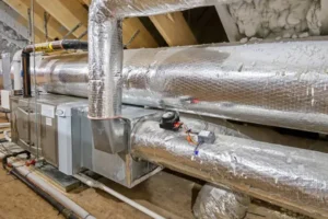 Ductwork in attic with insulation, showcasing HVAC system components for efficient air conditioning and energy savings.